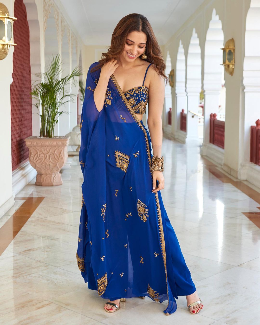 Royal blue lehenga where Tamannah can be seen in open cleavage choli with ornamented style plazo.